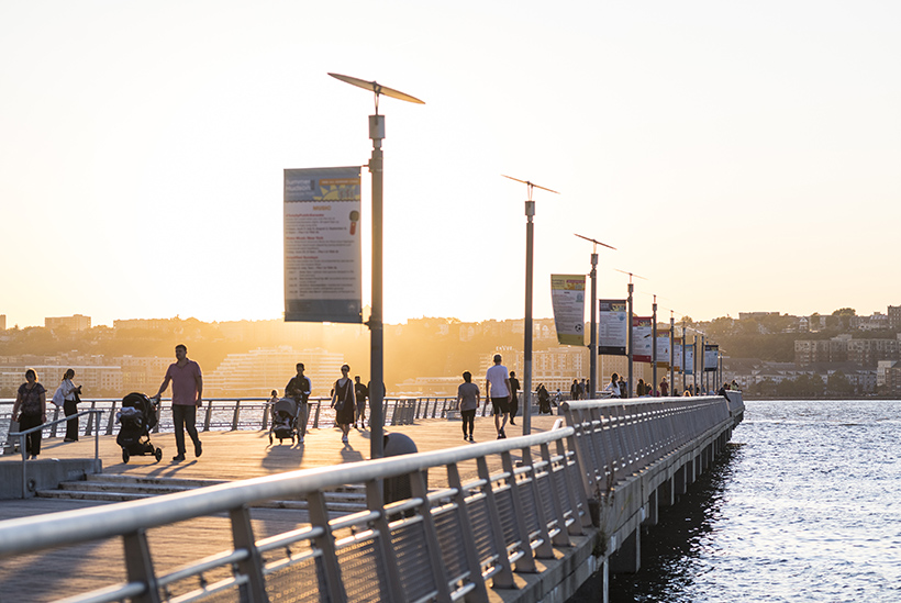 Image of people on a pier looking at the Hudson River